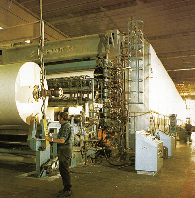 A man from Lange Lyche operates a large paper machine at Follum Paper mill, Norway